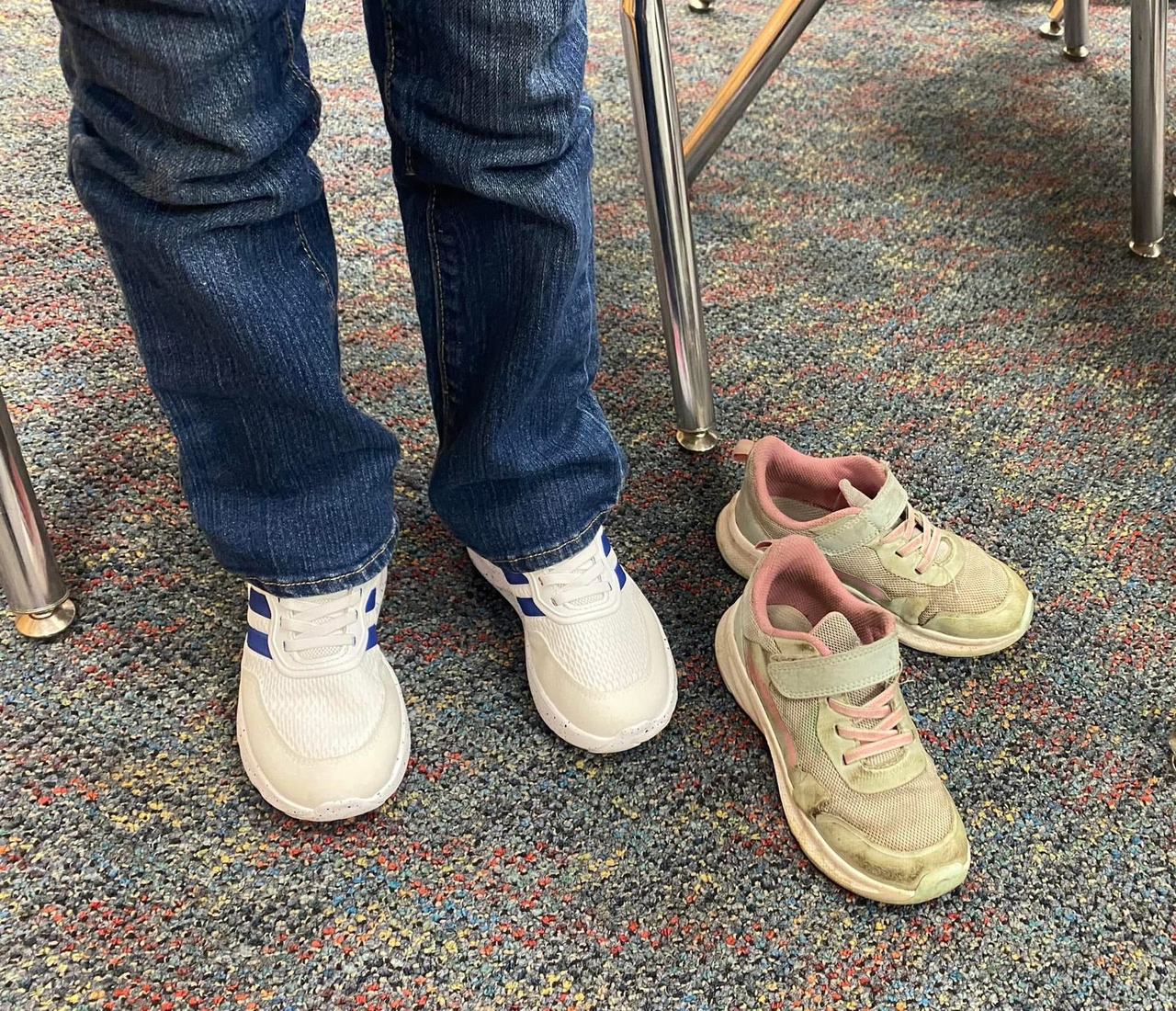 A child standing tall in brand-new white sneakers